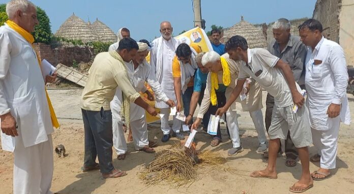 बिजली के बिल जलाते हुए सतबीर गोयत अन्य आप कार्यकर्ता