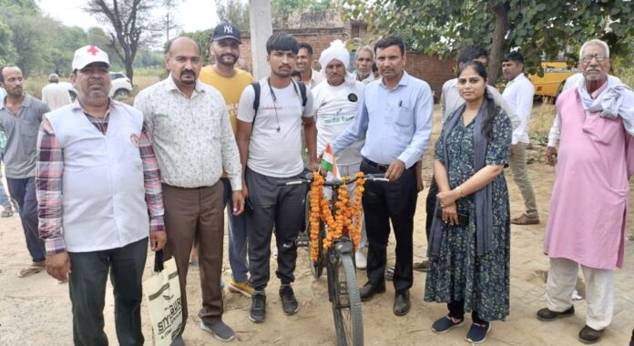 सुधीर को साइकिल वितरित करते एसडीएम सुरेंद्र कुमार।