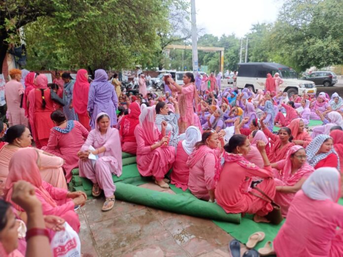 Anganwadi workers and helpers staged a sit-in protest over their demands