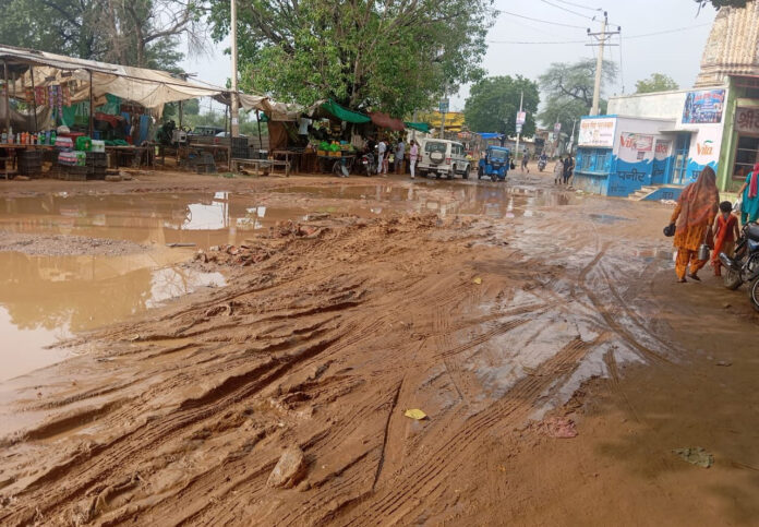 Water filled in the potholes of the damaged road in front of Shiv Mandir,