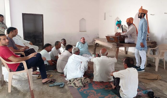 Artists giving information about government schemes to villagers.