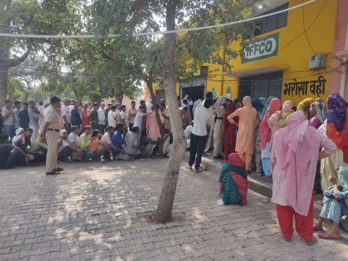 Long lines of farmers standing at the fertilizer link pack center